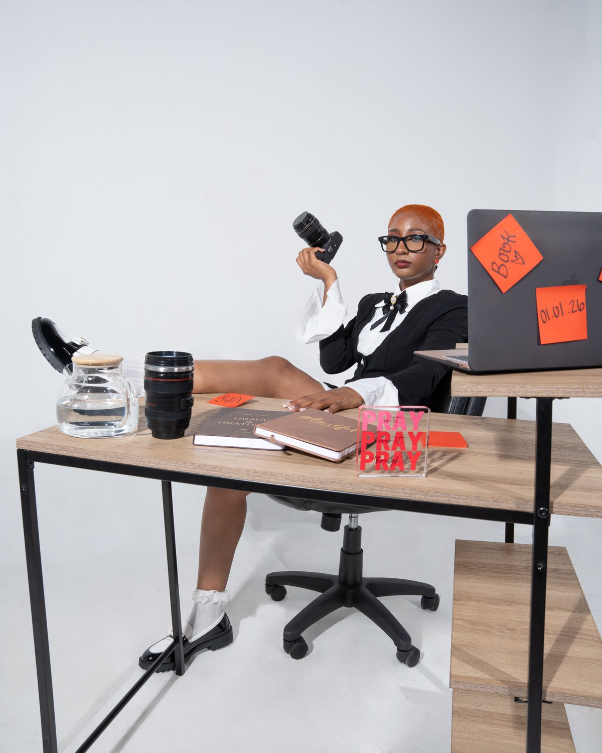 Sham, photographer and creative director, seated at a desk holding a camera
